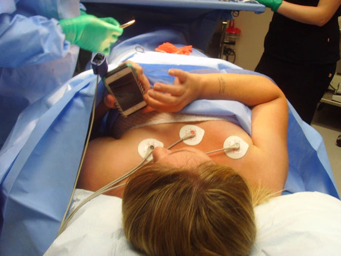 young woman getting a tummy tuck under local texting on her phone